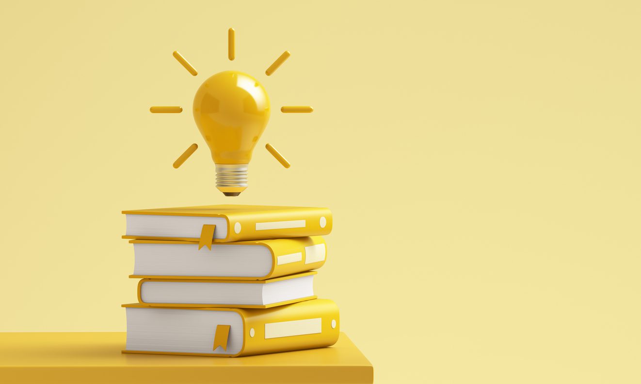 Yellow lightbulb glowing above stack of books on yellow background.