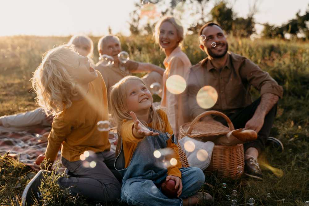 Family enjoying picnic and blowing bubbles at sunset