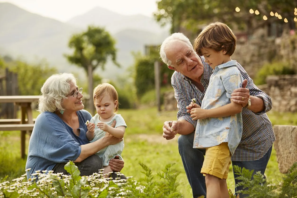 Elderly couple enjoying time with grandchildren outdoors