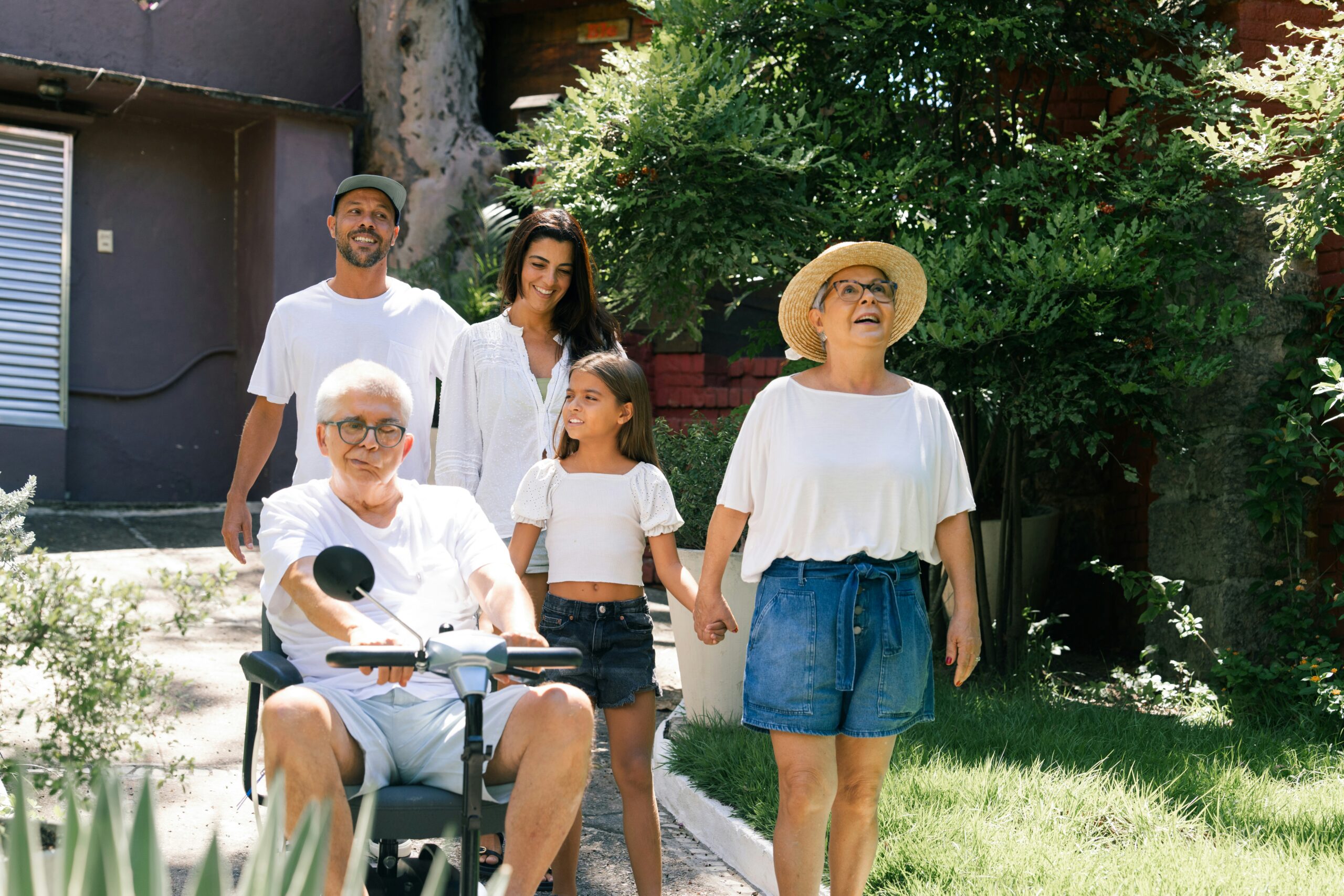 Family walking together, senior man in wheelchair