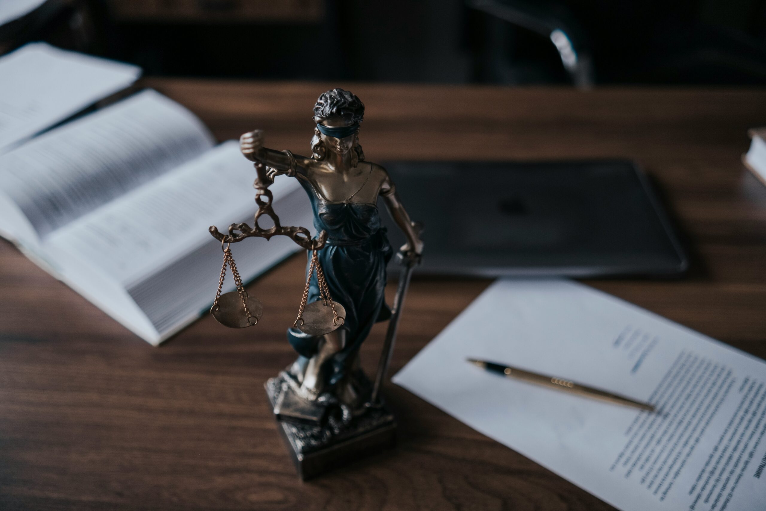 Lady Justice statue on desk with open books