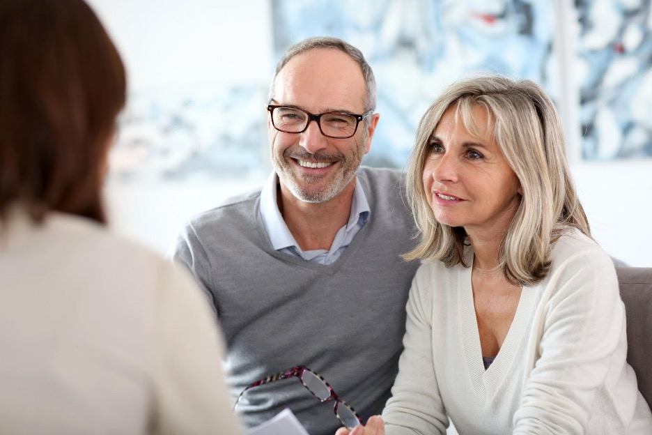 Mature couple consulting with professional in bright office